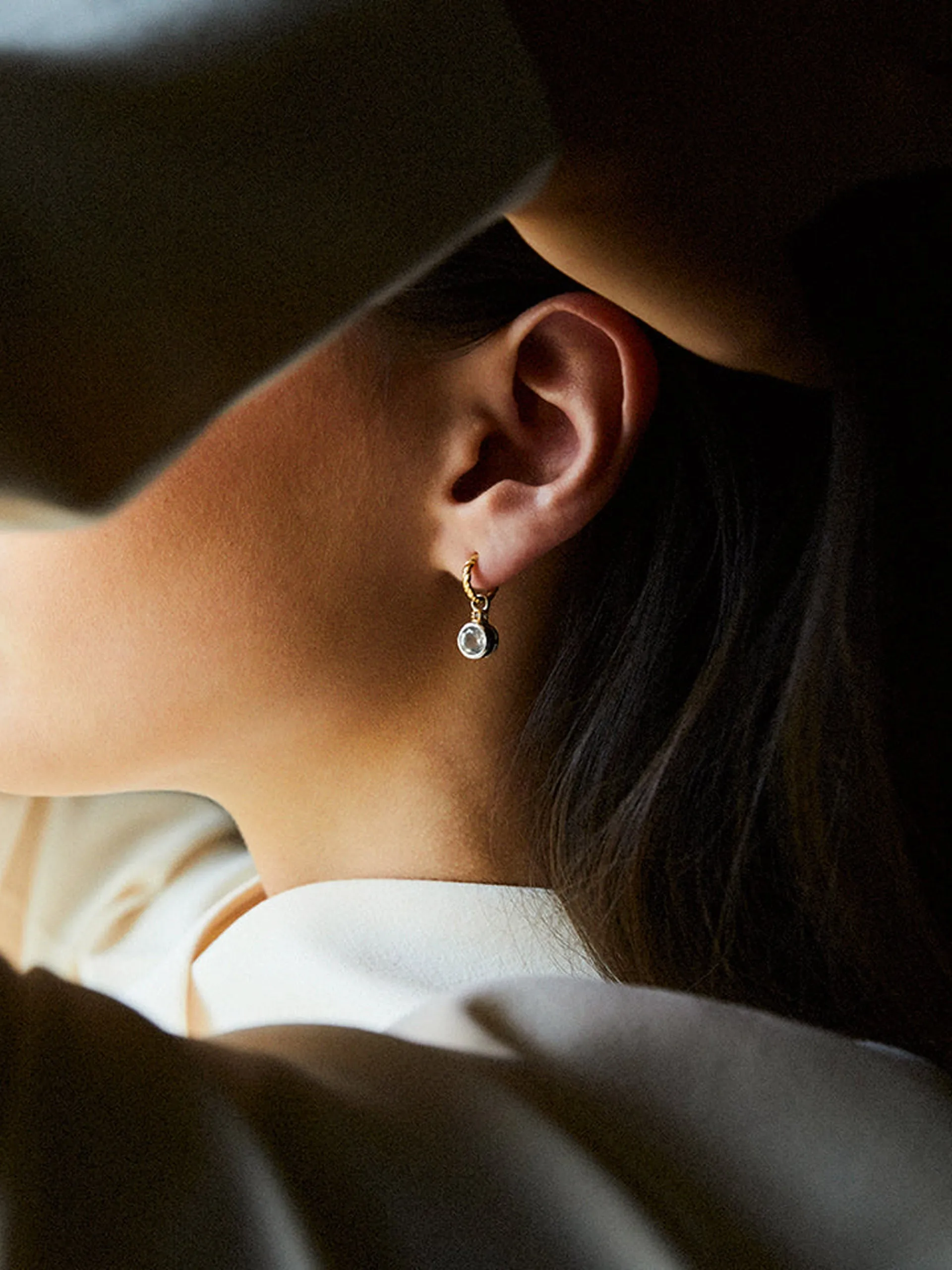Brilliant cut charms on twisted hoops